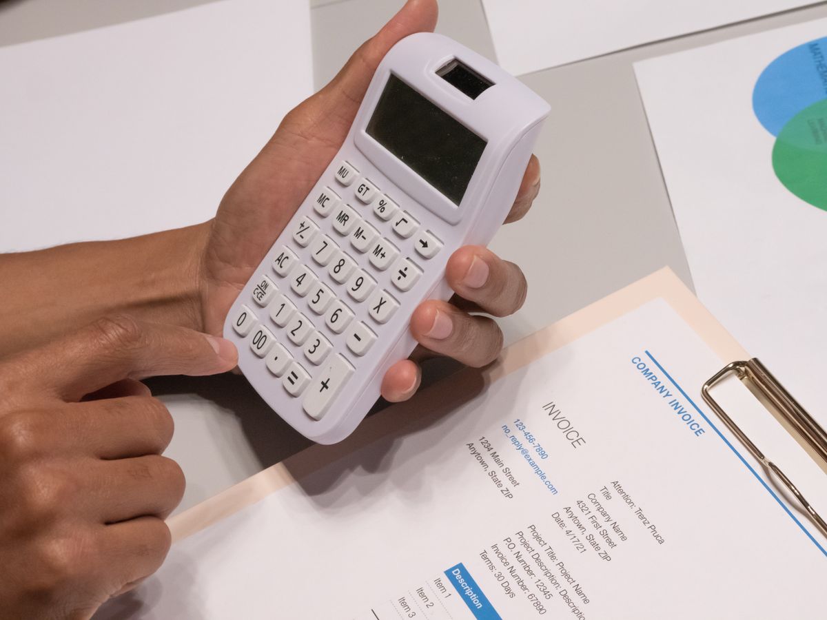 Händer räknar på en faktura med kalkylator